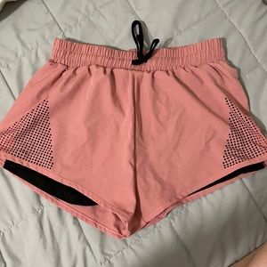 Pink laser cut athletic shorts with spandex lining